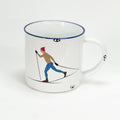 Vintage Keramiktasse im Emaille-look mit einem bunt gekleideten Langläufer